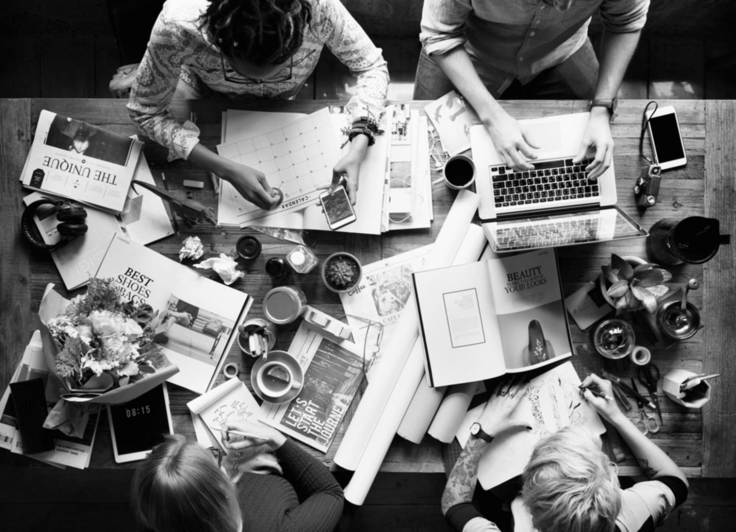 Detailed financial analysis charts and budget planning documentation spread across a conference table